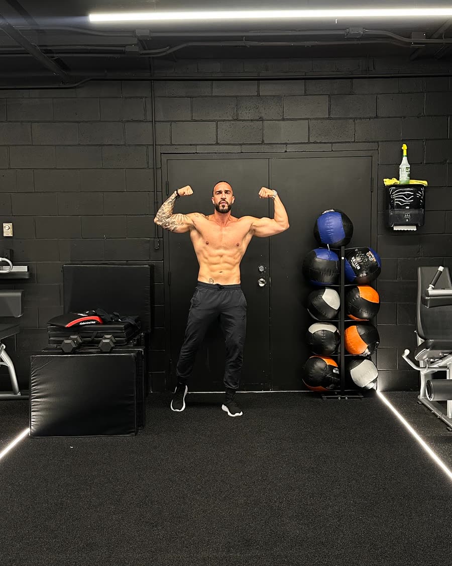 12-week transformation, after: front double-biceps pose in the gym